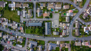 Top-down aerial view of densely packed urban houses with rooftops and narrow streets.