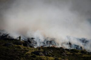 Firefighter tackling a moorland fire.